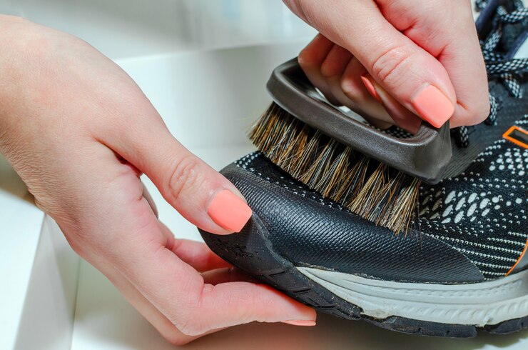 cleans-sports-shoes-woman-cleans-shoes-with-brush-cleaning-dirty-running-shoes_418821-859